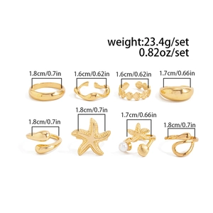 Detailed view of gold starfish and seashell rings set with size measurements in cm