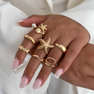 Gold bohemian ring set featuring starfish, shell, and pearl details for a stacked look