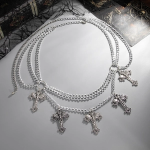 Detailed macro view of multilayered gothic silver chain with five cross and skull pendants
