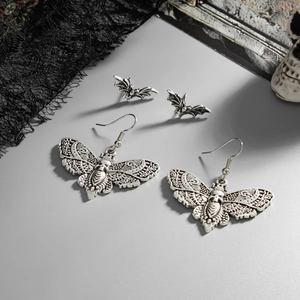 Set di orecchini goth con teschio falena e pipistrello su sfondo vintage scuro
