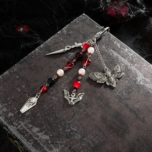 Gothic keychain detail featuring silver moth and skull pendants with red heart beads