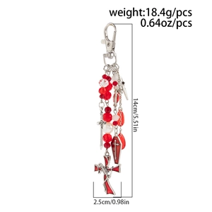 Gothic keychain detail with red beads, cross coffin charm, and sword on white background