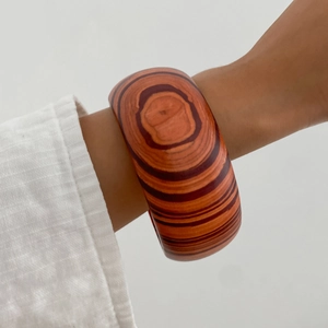 Bracciale rigido retrò in resina con venature del legno marrone su polso femminile