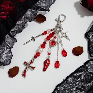 Gothic keychain with red cross and coffin charms on black lace and rose petals