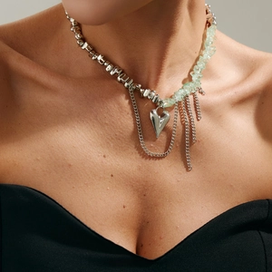 Collana con perline irregolari, pietre verdi e pendente a cuore indossata dal modello