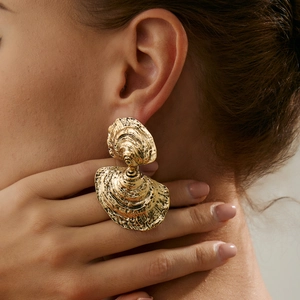 Detailansicht goldener unregelmäßiger Ohrringe mit Vintage-Korallen- und Muscheltexturen