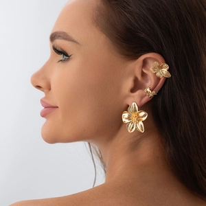 Detailaufnahme von goldenen Blumenohrringen und Ohrmanschetten im eleganten Vintage-Stil
