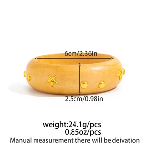 Detailed view of yellow wide bangle with gold star studs and measurement specifications