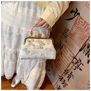 Dettaglio del ricamo a farfalla su borsa cheongsam con manico ad anello dorato