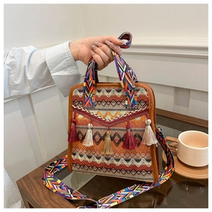 Dettaglio della borsa a secchiello bohémien con trame geometriche colorate e vivaci nappe