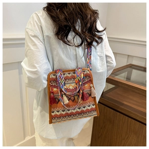 Dettaglio della borsa a secchiello boho con motivi etnici e nappe decorative laterali