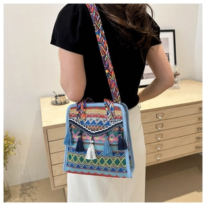 Dettaglio borsa a secchiello etnica intrecciata con nappe lunghe e tracolla larga colorata