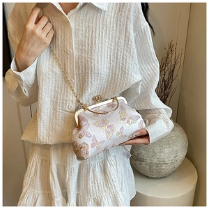 Ricamo dettagliato di farfalle viola e oro su una borsa a mano in seta vintage bianca