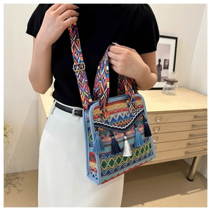 Dettaglio della borsa a secchiello boho intrecciata con motivi geometrici e nappe colorate