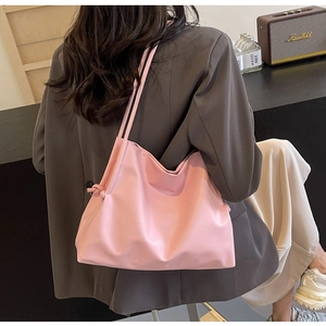 Dettaglio della borsa hobo rosa che mostra il materiale morbido e i nodi sulla tracolla