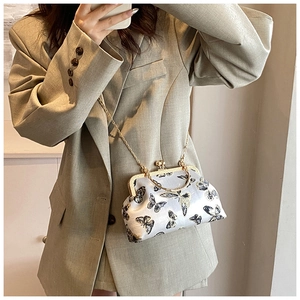 Dettaglio ricamo farfalla su clutch in raso grigio chiaro con telaio in metallo dorato