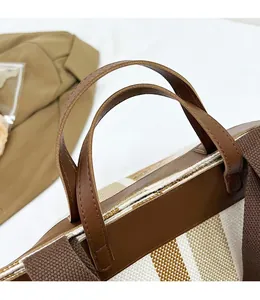 Dettaglio della borsa tote in tela con manici in pelle marrone e cuciture rifinite