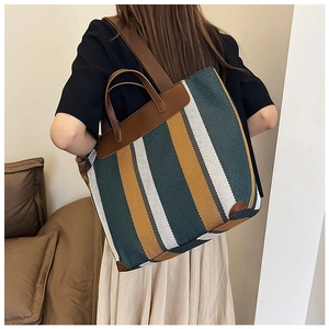 Dettaglio della grande borsa tote con strisce verticali verdi e gialle e manici in pelle