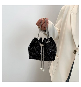 Détail du sac seau noir à paillettes avec chaîne argentée et breloques perles