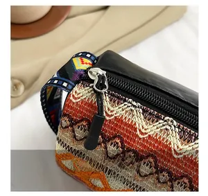 Dettaglio della borsa a secchiello intrecciata con finiture in pelle e zip in metallo