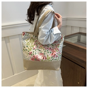 Dettaglio borsa tote in lino con stampa floreale vintage e tracolla in tessuto beige