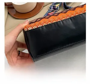Dettaglio delle cuciture di precisione e della trama boho sulla borsa a secchiello