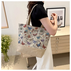 Dettaglio della borsa tote in lino con stampe di farfalle vintage e cuciture in tela
