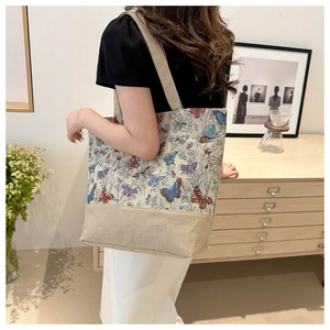 Vista dettagliata della borsa tote in lino vintage con farfalle colorate e fiori