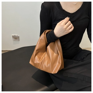 Dettaglio della borsa tote marrone cammello con cuciture verticali e trama opaca fine