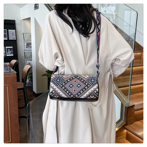 Borsa a secchiello boho con ricami geometrici e tracolla larga sulla modella