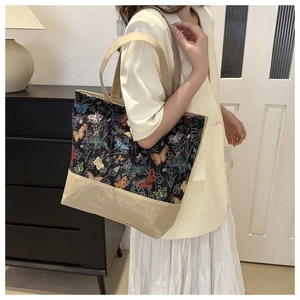 Borsa tote in lino con stampe di farfalle vintage sulla spalla della modella