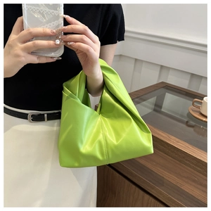 Dettaglio borsa a nuvola plissettata verde neon con manico a nodo in un selfie