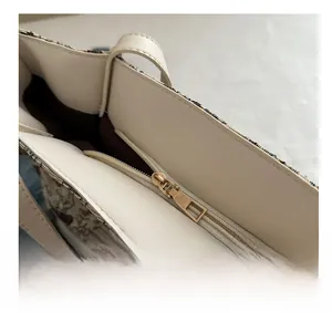 Detail of canvas tote bag with smooth gold zipper closure and dark brown fabric lining