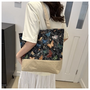 Dettaglio della borsa tote in lino vintage con ricami a farfalla colorati e manici in tela