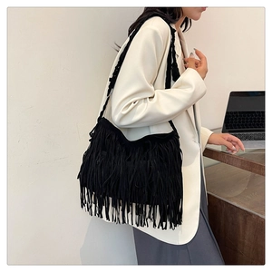 Dettaglio della borsa tote bohémien in pelle scamosciata nera con frange e tracolla intrecciata