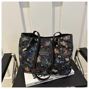 Detail of vintage tote bag with colorful butterfly embroidery on black jacquard fabric
