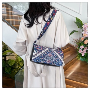 Dettaglio della borsa a secchiello boho con motivi intrecciati colorati e tracolla larga