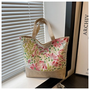 Dettaglio ravvicinato del ricamo floreale su una borsa tote in lino vintage con luce