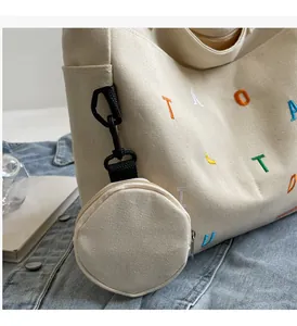Dettaglio borsa tote in tela con ricamo colorato e piccolo astuccio coordinato esterno