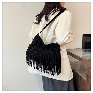 Dettaglio borsa a tracolla boho nera con lunghe nappe e tracolla con trama intrecciata