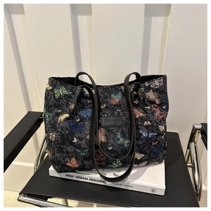 Detail of the high-capacity tote bag featuring woven butterfly patterns and leather straps