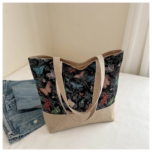 Dettaglio della borsa tote in lino con arazzo a farfalla e trama in tela beige