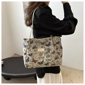 Detail view of large cream tote bag featuring colorful vintage butterfly print patterns