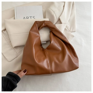 Dettaglio di una borsa tote in pelle PU marrone con trama opaca e design minimalista