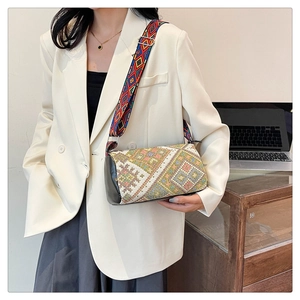 Dettaglio borsa a secchiello boho con motivi etnici intrecciati e inserti in pelle