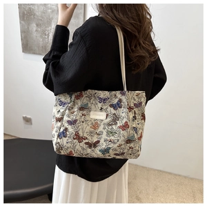Detailed view of the butterfly jacquard weave and leather patch on the large tote bag