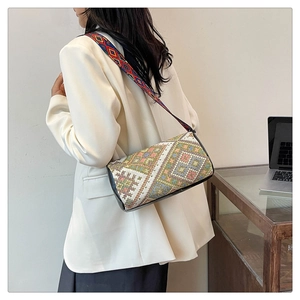 Dettaglio della borsa a secchiello boho con trama geometrica colorata e tracolla larga