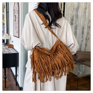 Dettaglio borsa a tracolla bohemian in pelle scamosciata marrone con nappe e tracolla