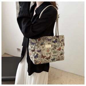 Detail of floral butterfly jacquard canvas tote bag with round leather logo patch