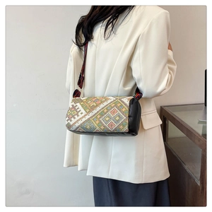 Dettaglio della borsa a secchiello boho con ricami geometrici e ampia tracolla jacquard